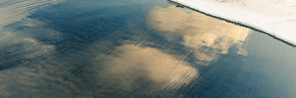glassy reflection of water on the shore